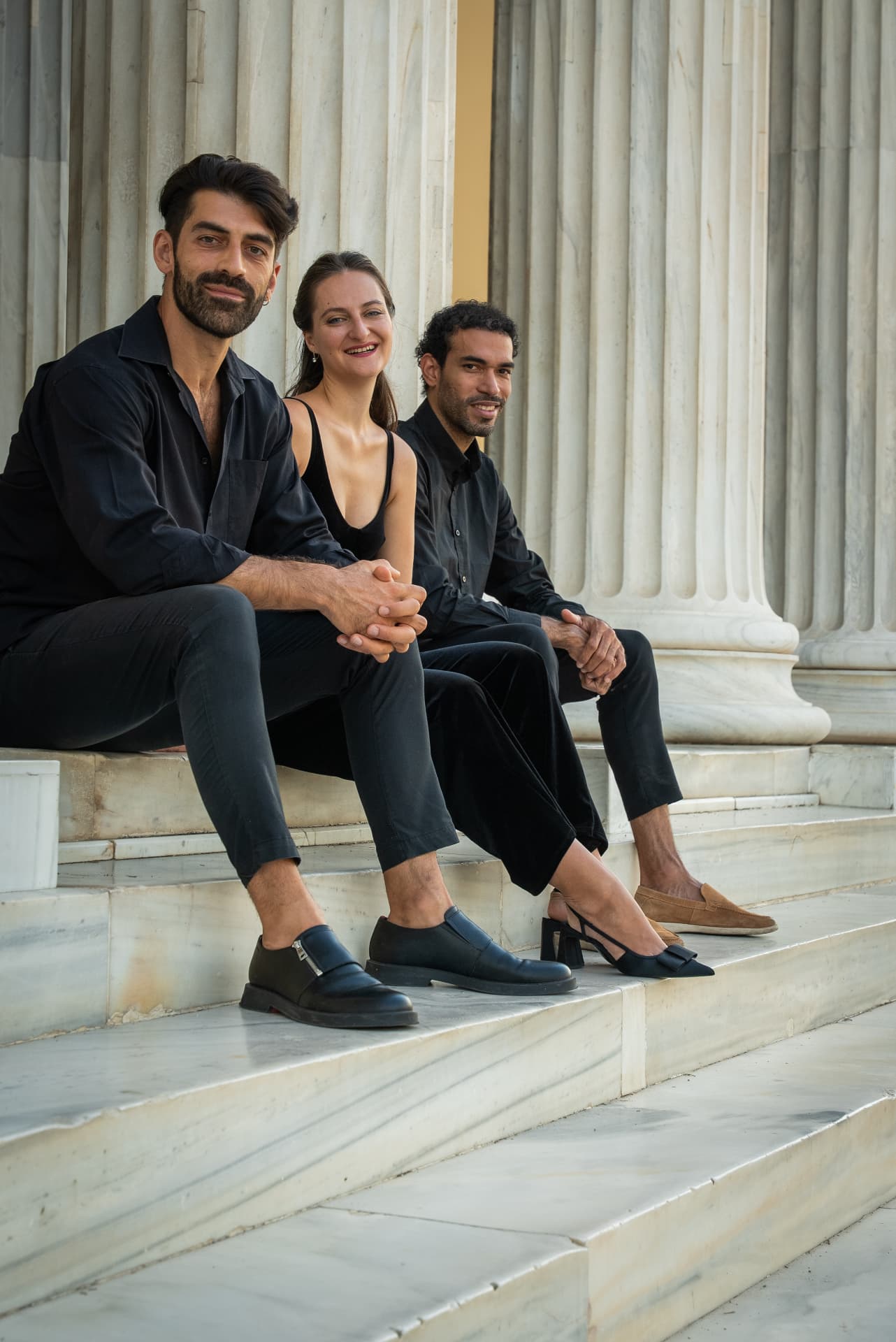 The trio seated on marble steps